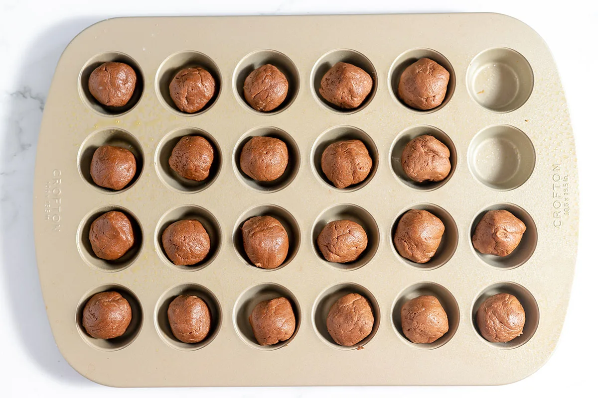 https://www.recipessimple.com/wp-content/uploads/2023/11/Cookie-dough-rolled-into-balls-in-muffin-tins.jpg.webp